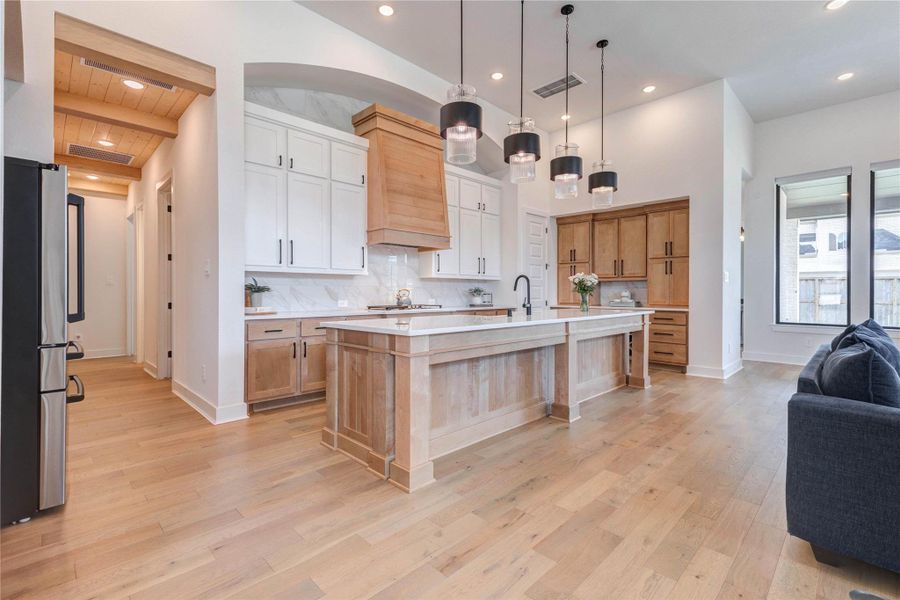 Modern kitchen features a spacious, open layout with light wood flooring, a large central island, and sleek cabinetry. Pendant lights add elegance, while stainless steel appliances and ample natural light enhance functionality and ambiance. Modern kitchen features a spacious, open layout with light wood flooring, a large central island, and sleek cabinetry. Pendant lights add elegance, while stainless steel appliances and ample natural light enhance functionality and ambiance.