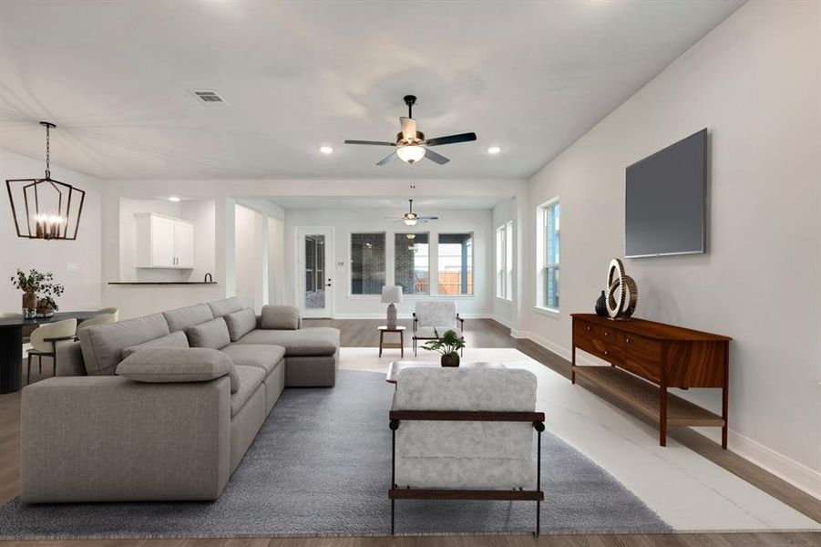 Living room featuring light wood-style flooring, a ceiling fan, and a chandelier