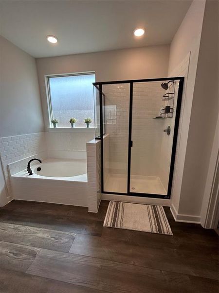 Full bath featuring a garden tub, a shower stall, dark wood-type flooring, and recessed lighting Full bath featuring a garden tub, a shower stall, dark wood-type flooring, and recessed lighting