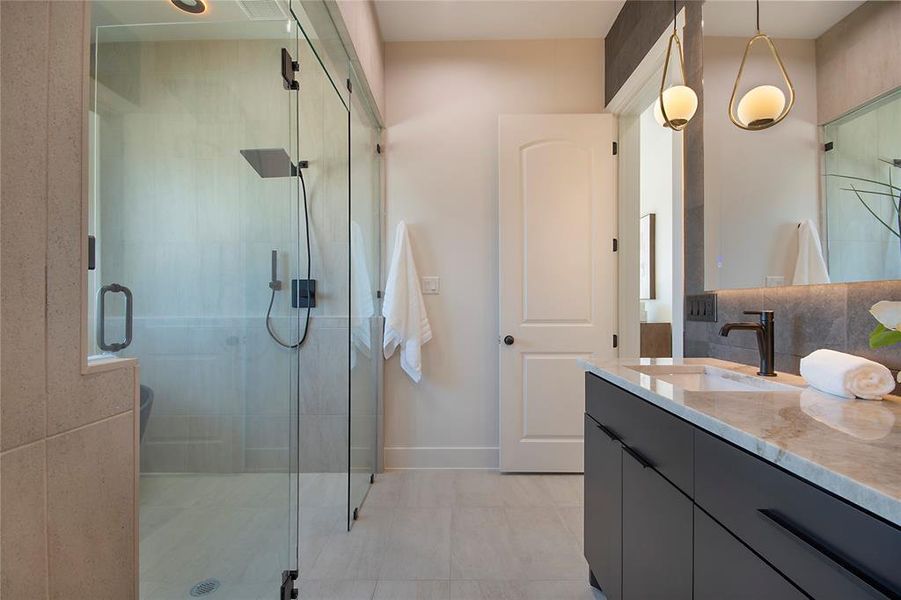 Full bath featuring vanity, a stall shower, and light tile patterned flooring Full bath featuring vanity, a stall shower, and light tile patterned flooring