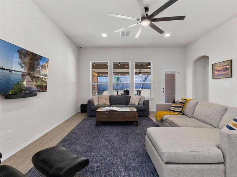 Living room featuring ceiling fan, arched walkways, wood finished tiled floors, and recessed lighting