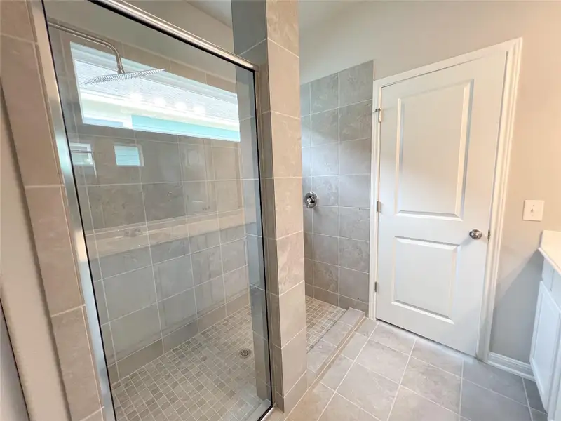 Full bath with a shower stall, vanity, and light tile patterned floors