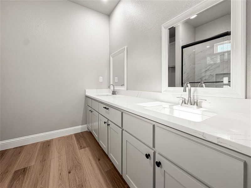 Double vanity featuring shaker-style cabinetry, white countertops, and undermount sinks