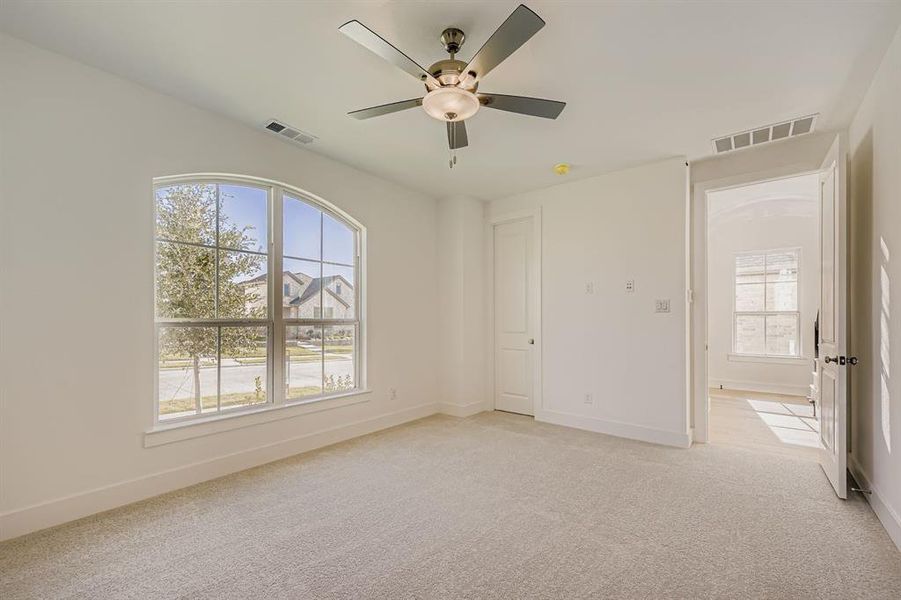 Unfurnished bedroom featuring light colored carpet and ceiling fan