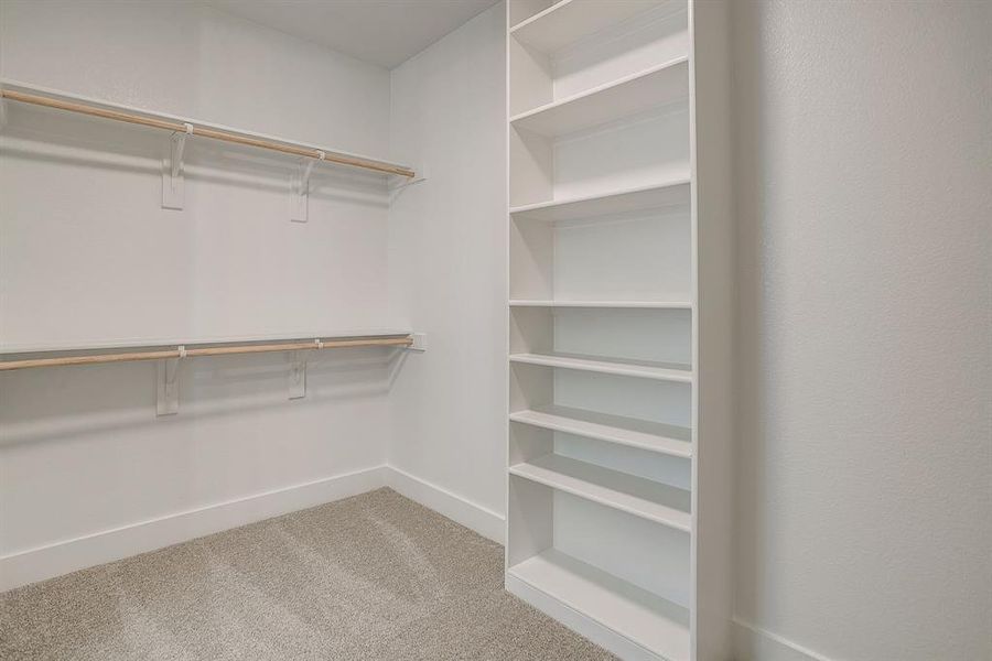 Walk in closet featuring light colored carpet Walk in closet featuring light colored carpet