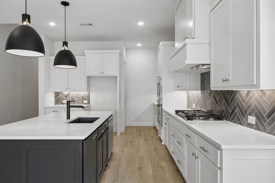 Two tone cabinetry, gorgeous counter tops and designer selected backsplash effortlessly pair with contemporary stainless steel to create a kitchen for the ages!