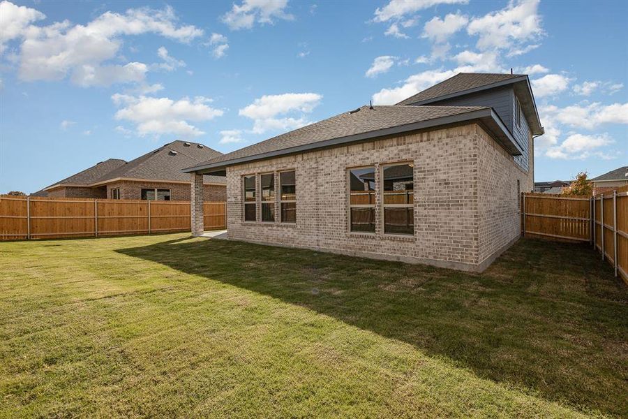 Rear view of property featuring a lawn