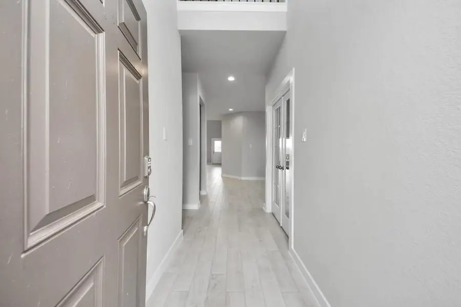 As you step into the threshold of this luxurious home, you'll soon be welcomed by an elegant glass door (to be installed). Inside, soaring ceilings amplify the spaciousness, while the refined wood-look tile flooring and oversized baseboards exude sophistication and charm. Sample photo of completed home with similar floor plan. Actual colors and selections may vary.