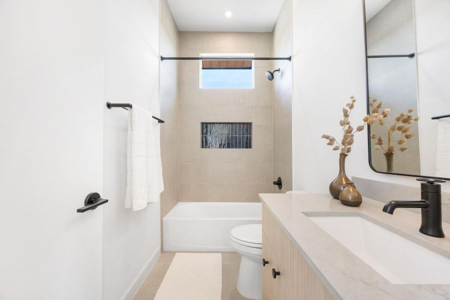 Contemporary bathroom featuring a tub/shower combination with light-toned tile surround and a rectangular inset shelf
