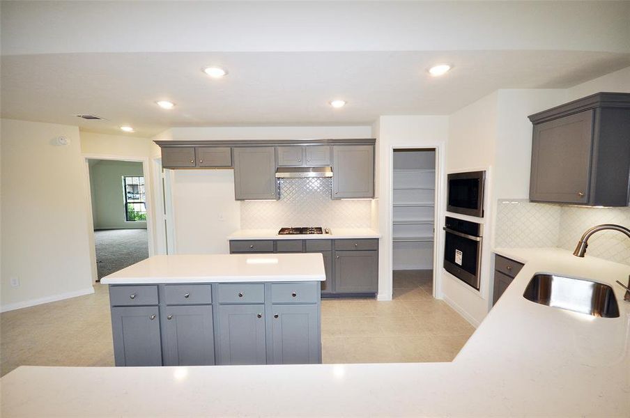 Family and friends interact with the chef over this quart stone bar top with room for 6.