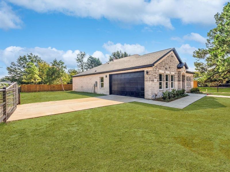 View of side of home featuring brick siding, driveway, and an attached garage