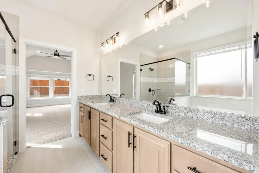 Master bathroom with double vanity, granite countertops, and glass shower enclosure Master bathroom with double vanity, granite countertops, and glass shower enclosure