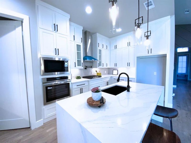 Chefs kitchen with floor to ceiling cabinets, gas cooktop, pot filler, stainless steal appliances