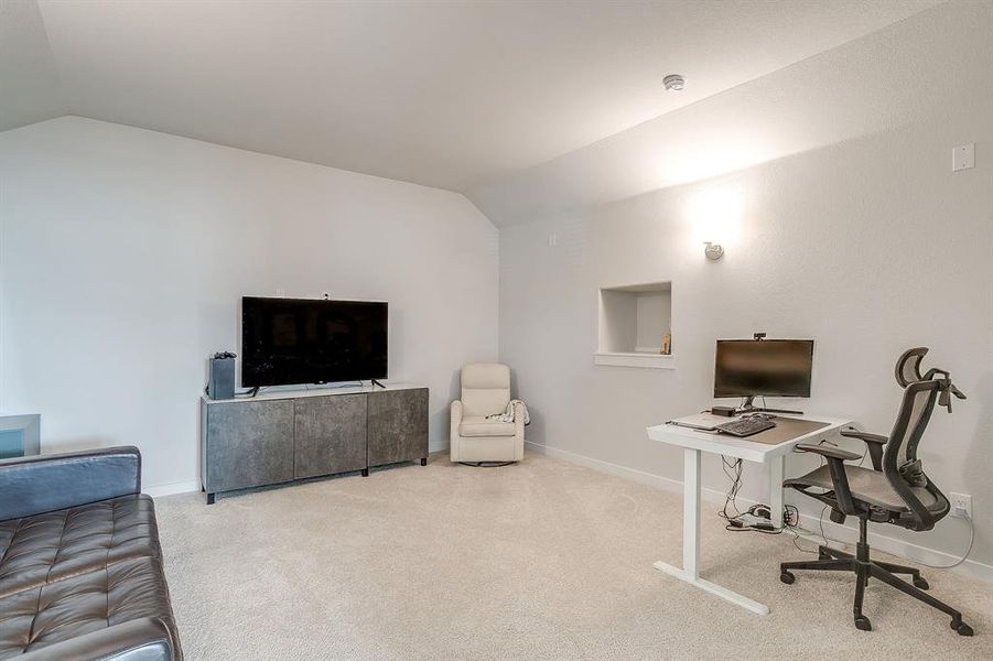 Office space featuring lofted ceiling and carpet floors Office space featuring lofted ceiling and carpet floors