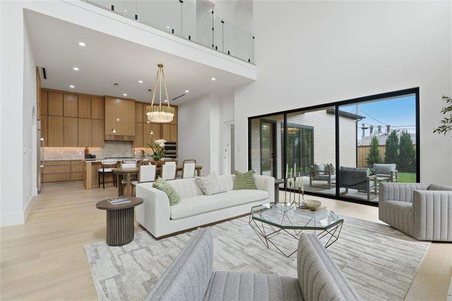 Open-concept living area with soaring ceilings and light wood-finish flooring Open-concept living area with soaring ceilings and light wood-finish flooring