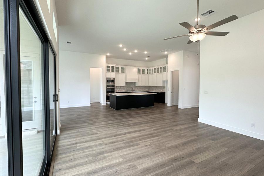 An open-concept living space with a contemporary kitchen and sliding glass doors leading to the outdoors.