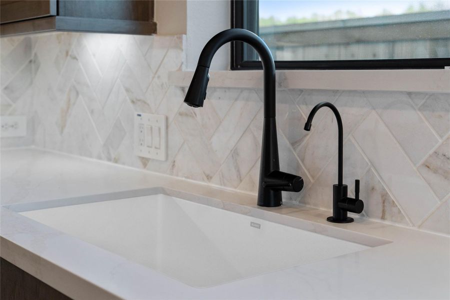 The white undermount sink is perfectly situated beneath a bright window, offering a pleasant view of the outdoors. The white undermount sink is perfectly situated beneath a bright window, offering a pleasant view of the outdoors.