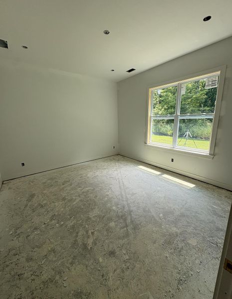 Spacious interior room featuring a large window, recessed lighting, and a neutral color palette Spacious interior room featuring a large window, recessed lighting, and a neutral color palette