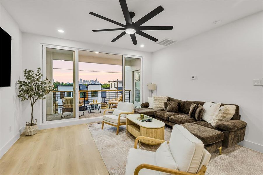 Living area with light wood-style flooring, recessed lighting, and a ceiling fan