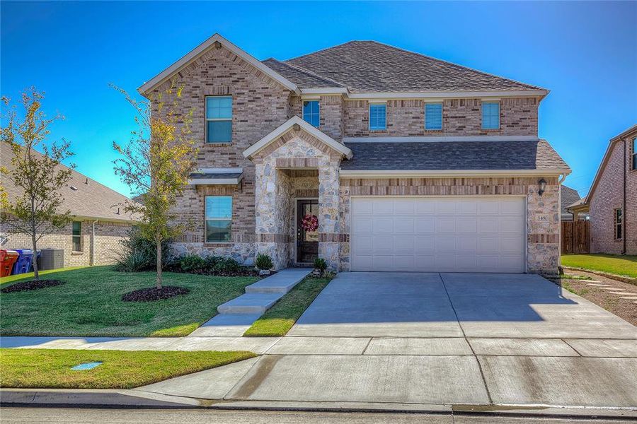 View of front of house with a front yard and a garage