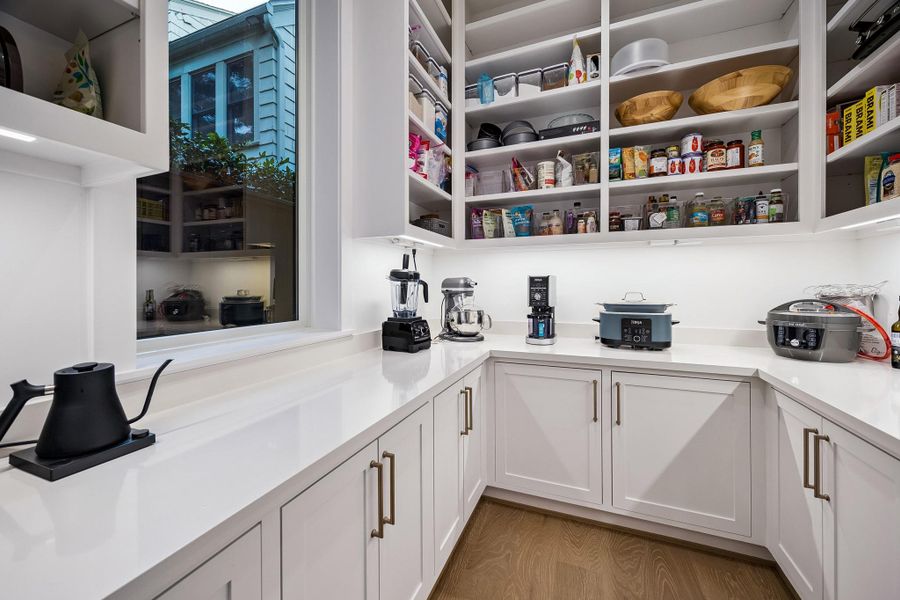 Keep small appliances neatly tucked away in this expansive working pantry, designed for both function and organization.
