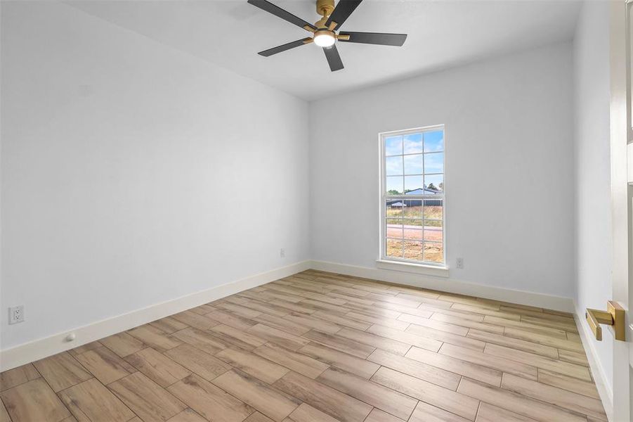 Empty room featuring wood finish floors and a ceiling fan