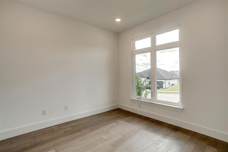 Empty room with a healthy amount of sunlight and hardwood / wood-style flooring