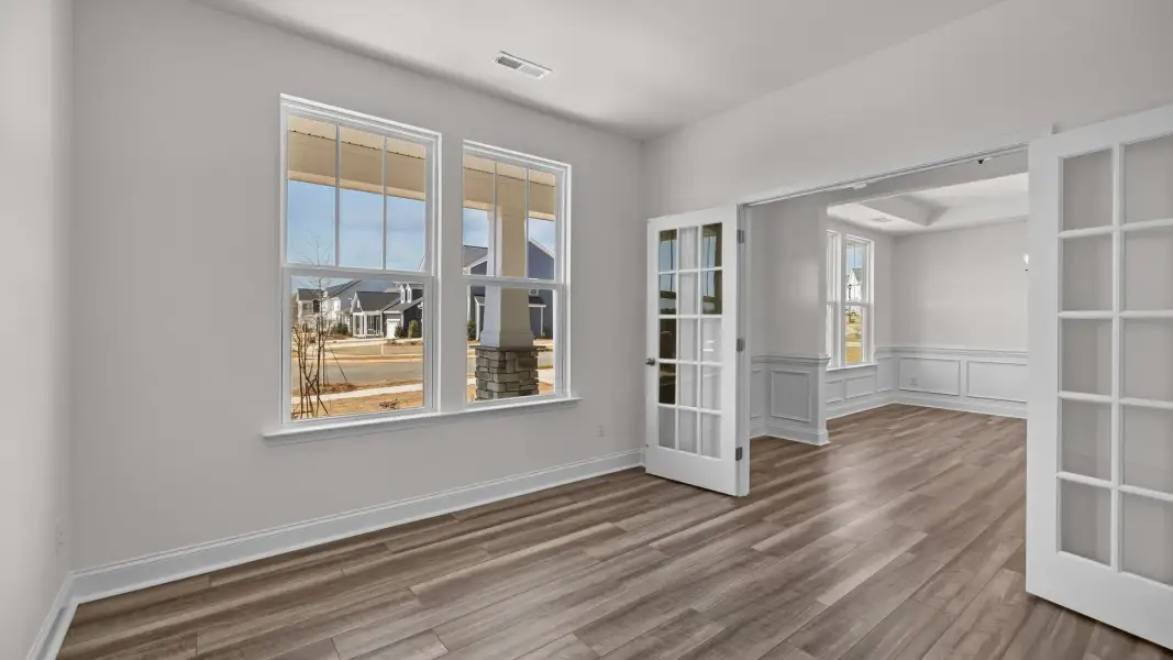 Flexible and bright study with elevated ceiling, large windows, and double French doors, in the Norris Design by DRB Homes Flexible and bright study with elevated ceiling, large windows, and double French doors, in the Norris Design by DRB Homes