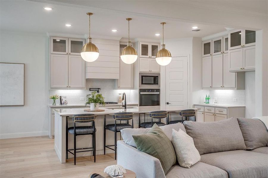 Kitchen featuring white cabinets, a kitchen island with sink, black appliances, and sink