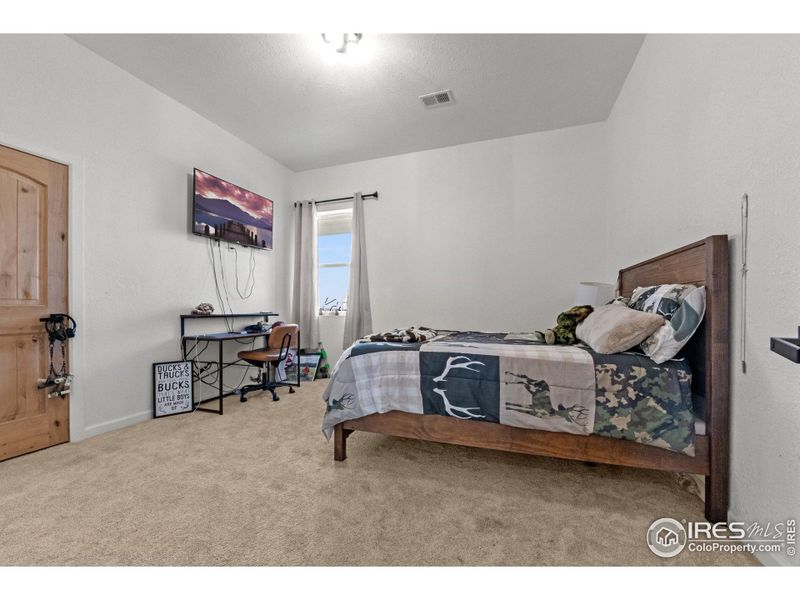 Comfortable secondary bedroom with soft natural light and plenty of space