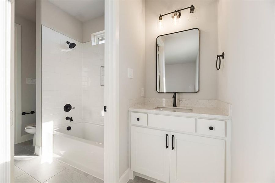 Full bath with washtub / shower combination, vanity, and light tile patterned flooring Full bath with washtub / shower combination, vanity, and light tile patterned flooring