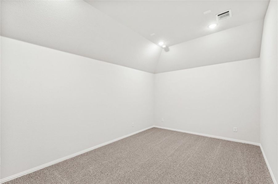 Empty room with white walls, gray carpet, recessed lighting, and vaulted ceiling