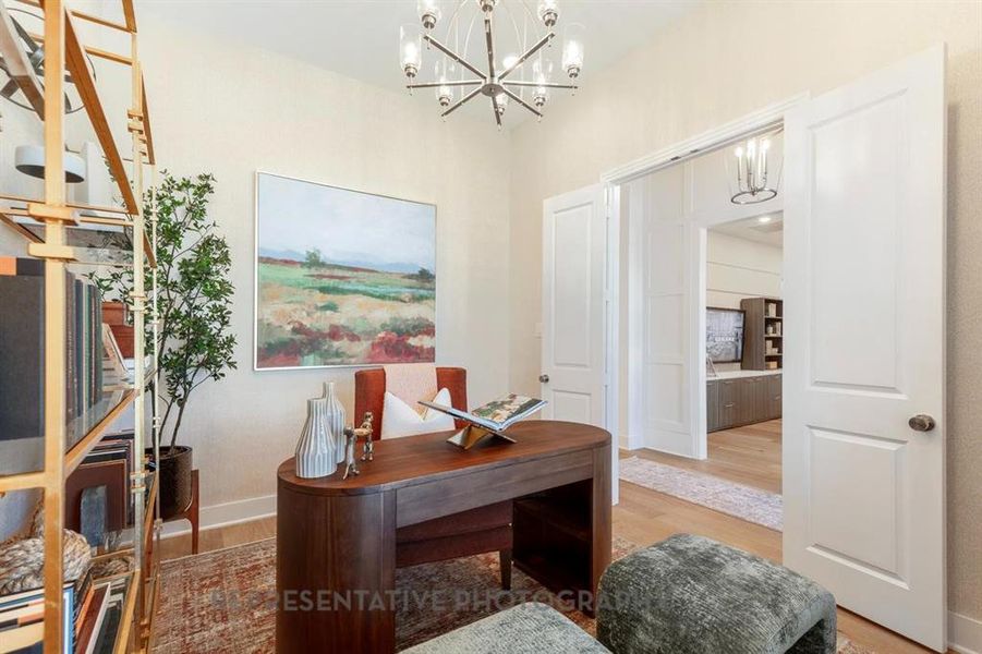 Office featuring light wood finished floors and a chandelier