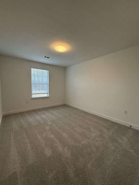 Empty room with light colored carpet and baseboards