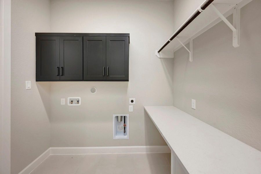 Cabinets at utility that is plumbed for gas and electric and a folding table too!