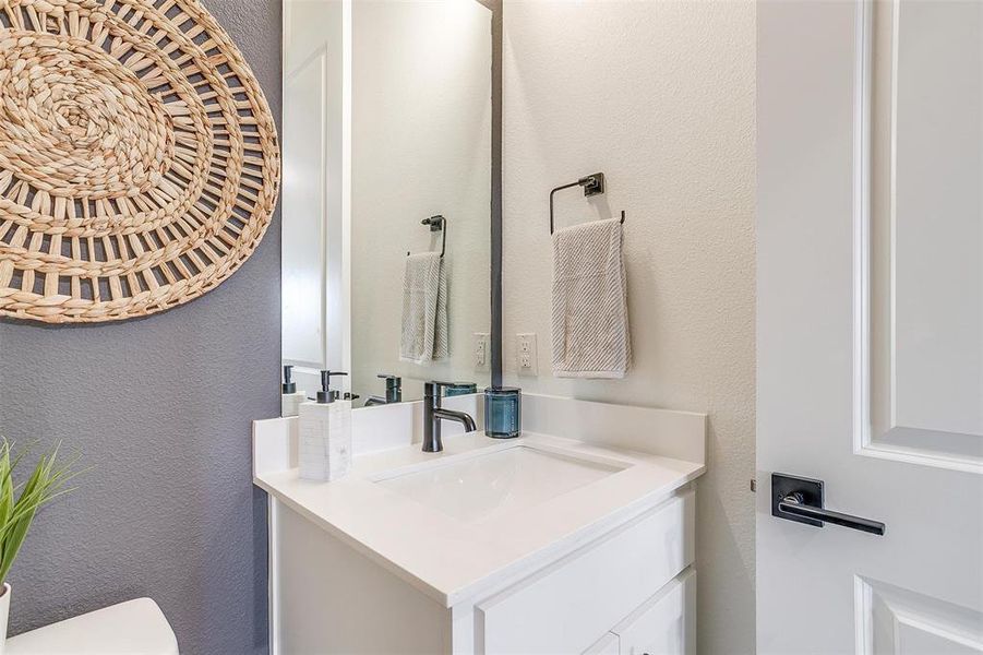 Bathroom featuring a textured wall and vanity Bathroom featuring a textured wall and vanity