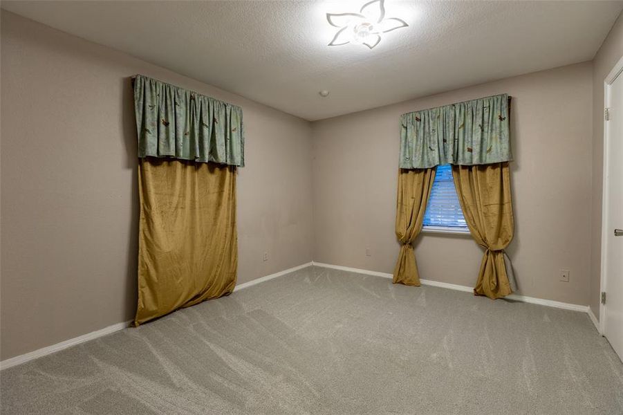 Unfurnished room with light carpet and a textured ceiling Unfurnished room with light carpet and a textured ceiling