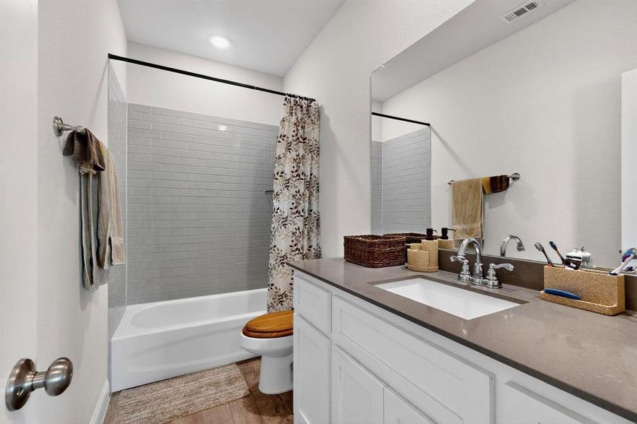 Full bathroom with shower / bath combo, vanity, and light tile patterned flooring Full bathroom with shower / bath combo, vanity, and light tile patterned flooring