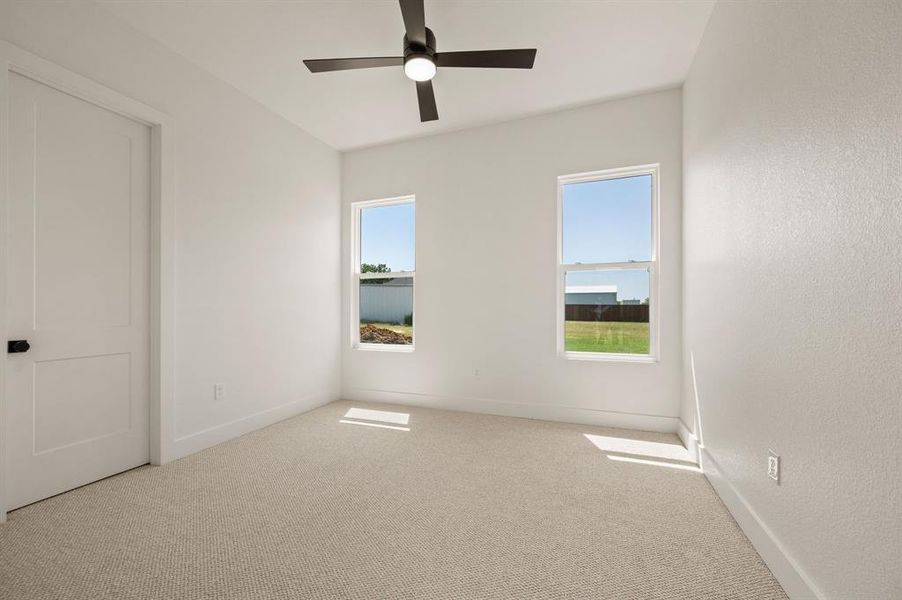 Spare room with carpet flooring and a ceiling fan Spare room with carpet flooring and a ceiling fan