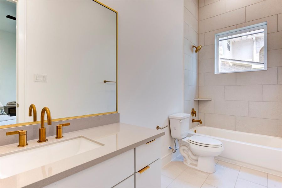 Large full-size bathroom on the first floor featuring elegant gold hardware and finishes.