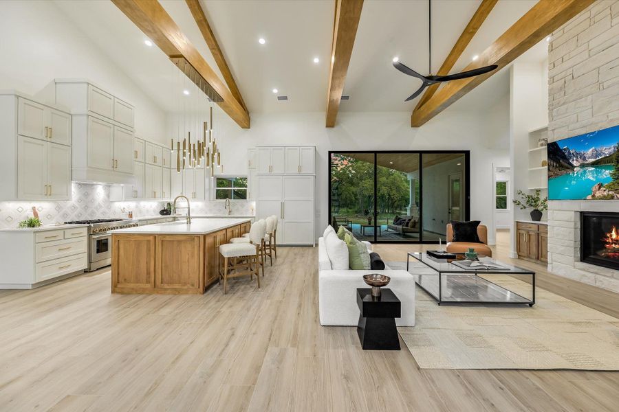 Living area featuring light wood-style floors, a stone fireplace, built in features, and recessed lighting