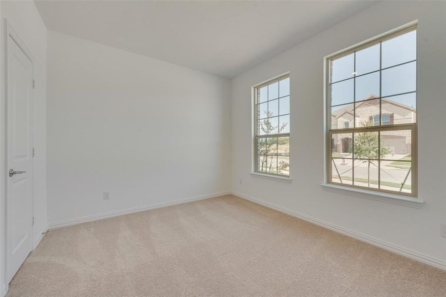 Empty room featuring light colored carpet and a healthy amount of sunlight