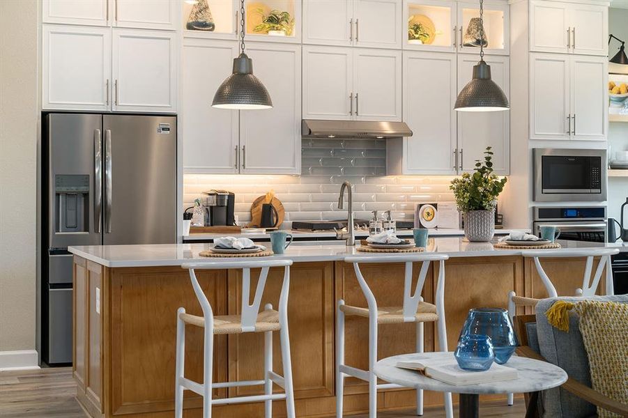 Gorgeous Kitchen with cabinets to ceiling, accented island/breakfast bar, refrigerator & quartz counters!