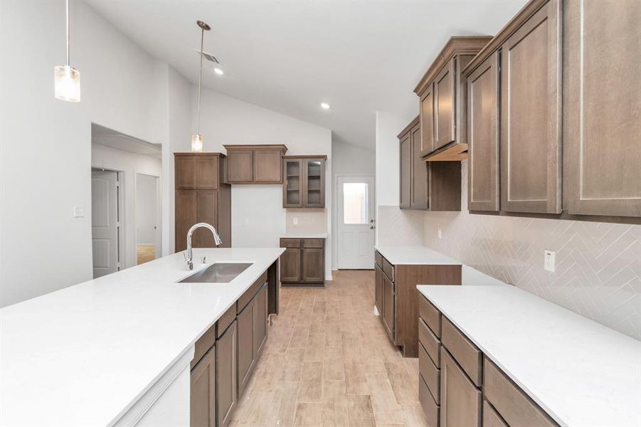 Experience the luxury of this well-appointed kitchen, boasting modern cabinetry, sleek countertops, and stainless steel fixtures. The open layout ensures you are always part of the action, whether cooking, dining, or entertaining guests. Quality craftsmanship is evident in every detail. **This image is from another Saratoga Home - Clover floorplan.**