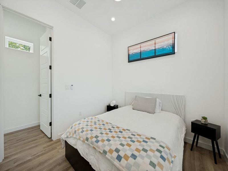 A naturally illuminated bedroom offers versatile flooring and crisp, white walls. A naturally illuminated bedroom offers versatile flooring and crisp, white walls.