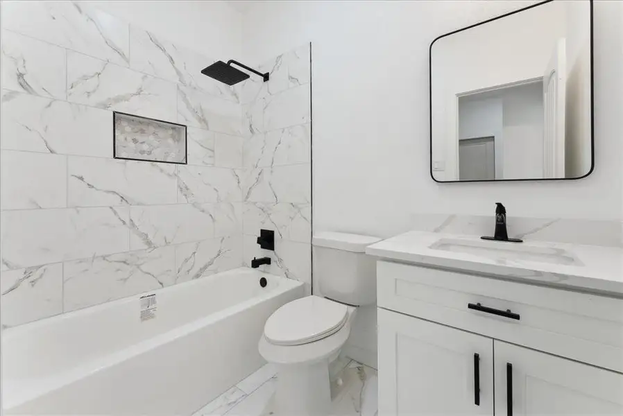 Bathroom with marble finish floor, vanity, toilet, and shower / bathtub combination