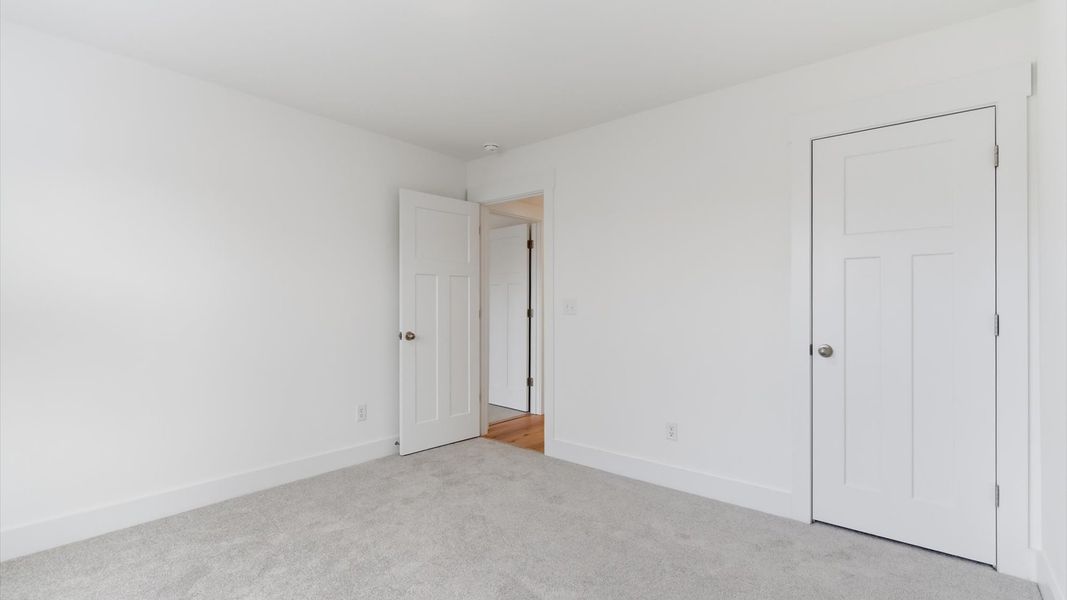 Accomplished design shines in this carpeted bedroom with a functional walk-in closet