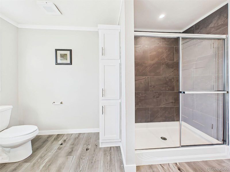 Walk-In Shower & Storage – The primary bath includes a sleek, glass-enclosed shower with rich tile surround and a built-in linen cabinet for added convenience.