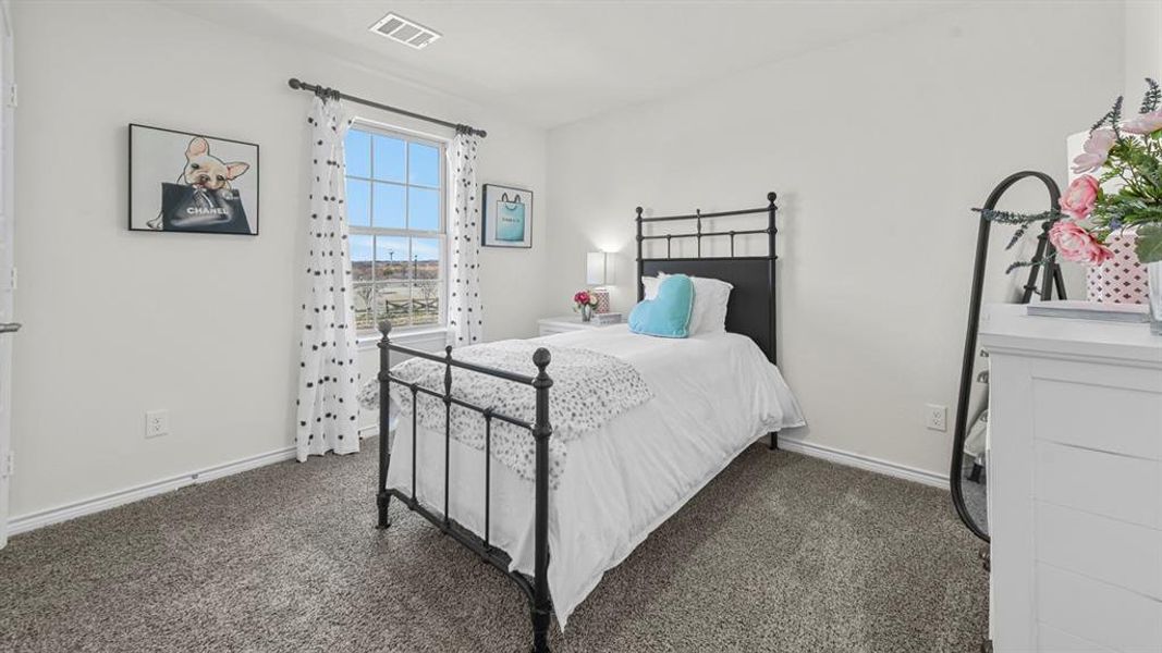 Room with light gray carpet, white walls, and a window featuring white blinds and decorative curtains