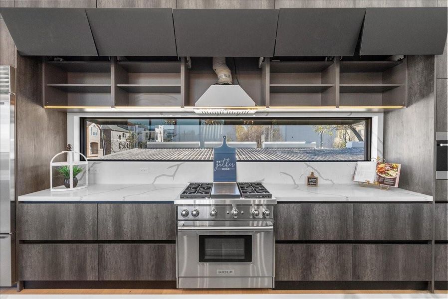 The high-end kitchen features motorized cabinets and shelving with oversized cabinetry designed for both beauty and function.